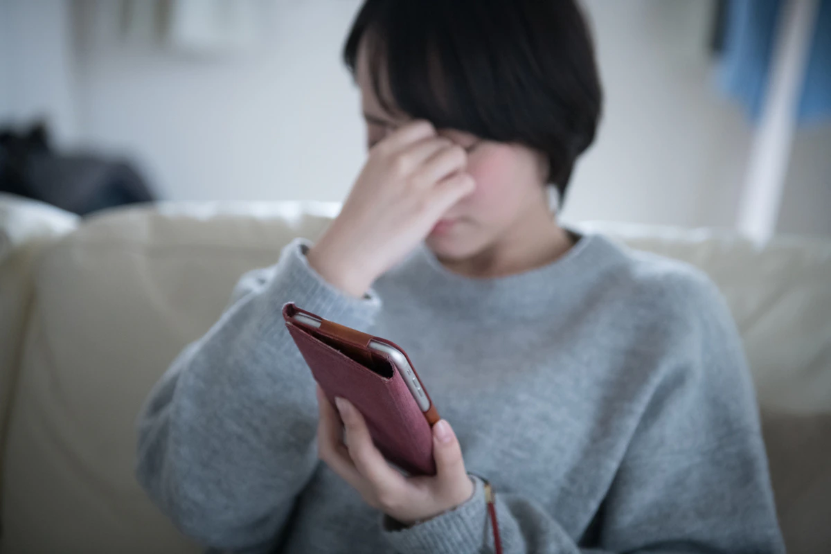 女性　眉間　スマホ　リビング