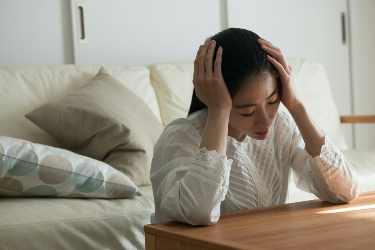 悩む　女性　室内　日本人
