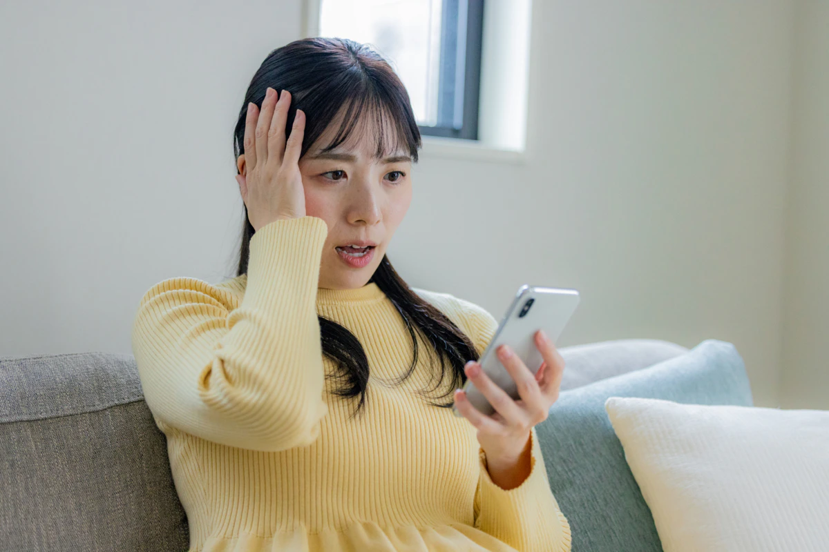 スマホ　ショック　女性　リビング　