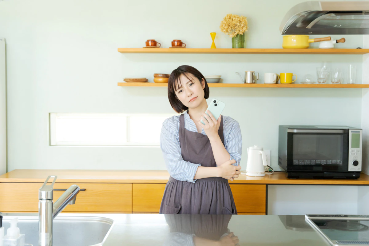女性　スマホ　イライラ　キッチン