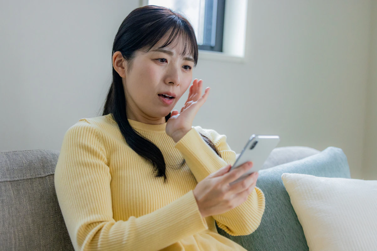 女性　悩む　スマホ
