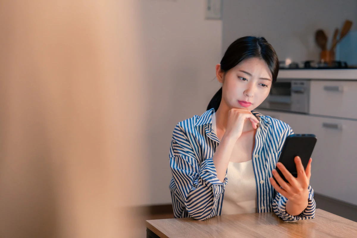 スマホ　若い女性　モヤモヤ