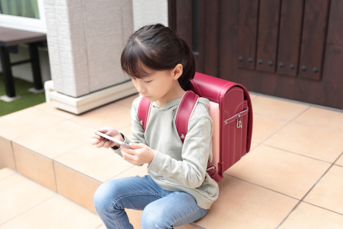子ども　ランドセル　外　座る　一人