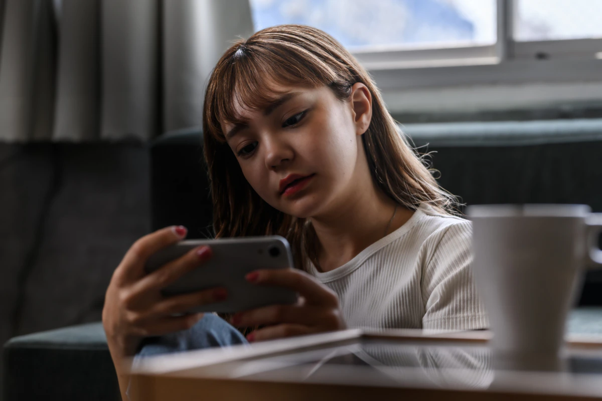 女性　茶髪　横顔　スマホ　暗い