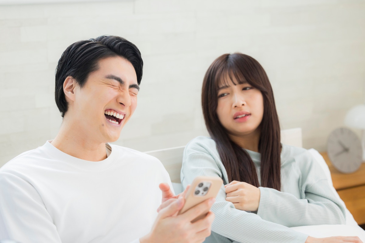 スマホ　怒る　女性　リビング