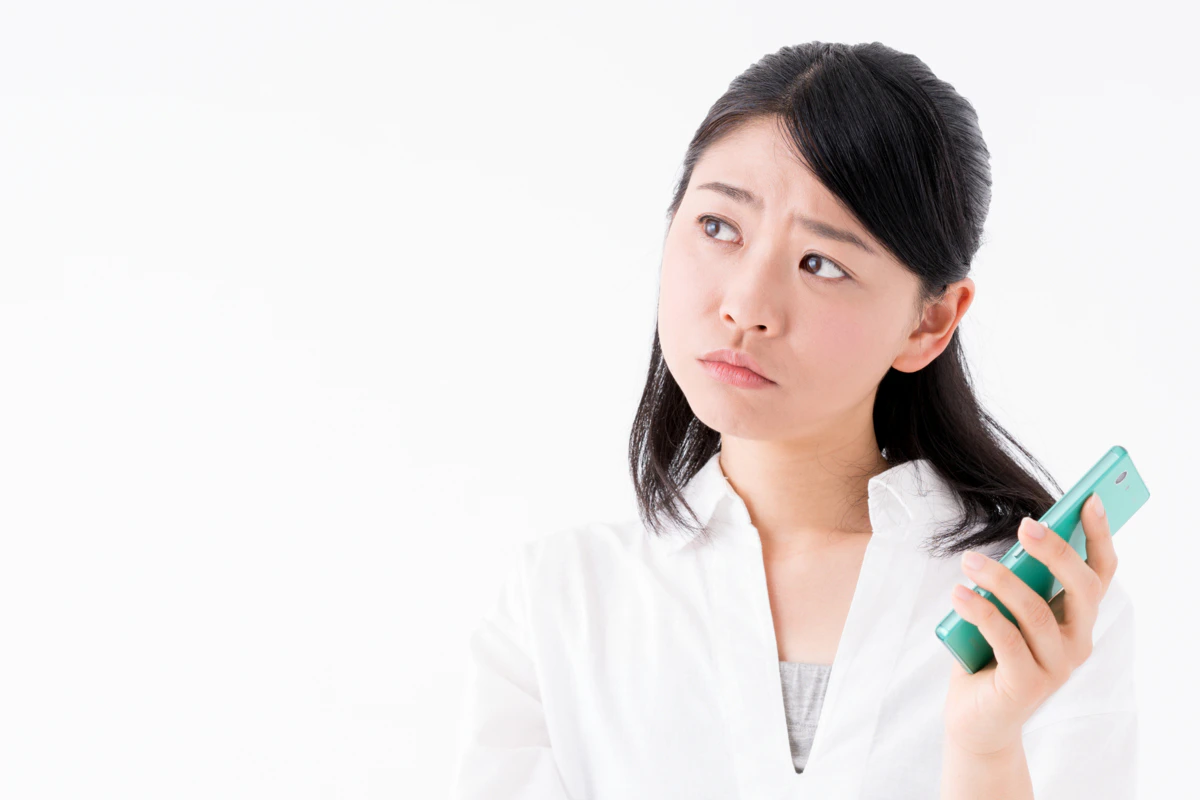 スマホ　女性　困り顔