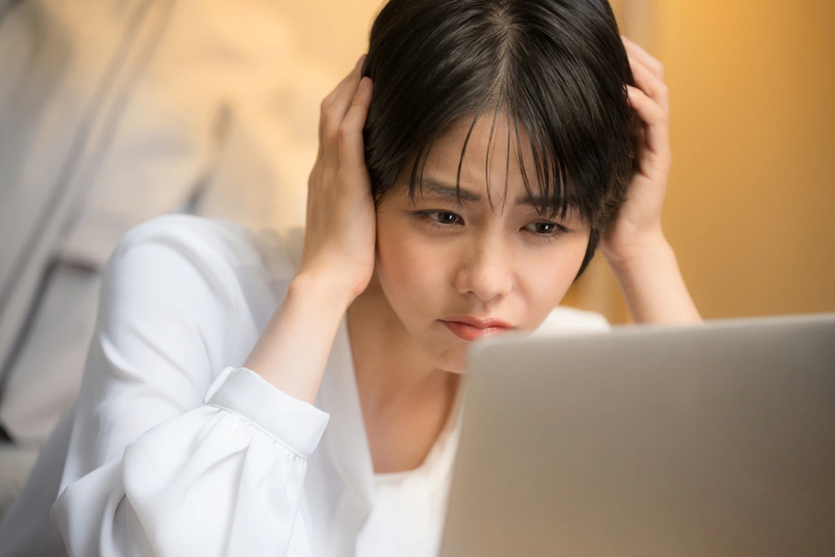 パソコン　頭を抱える　女性　リビング