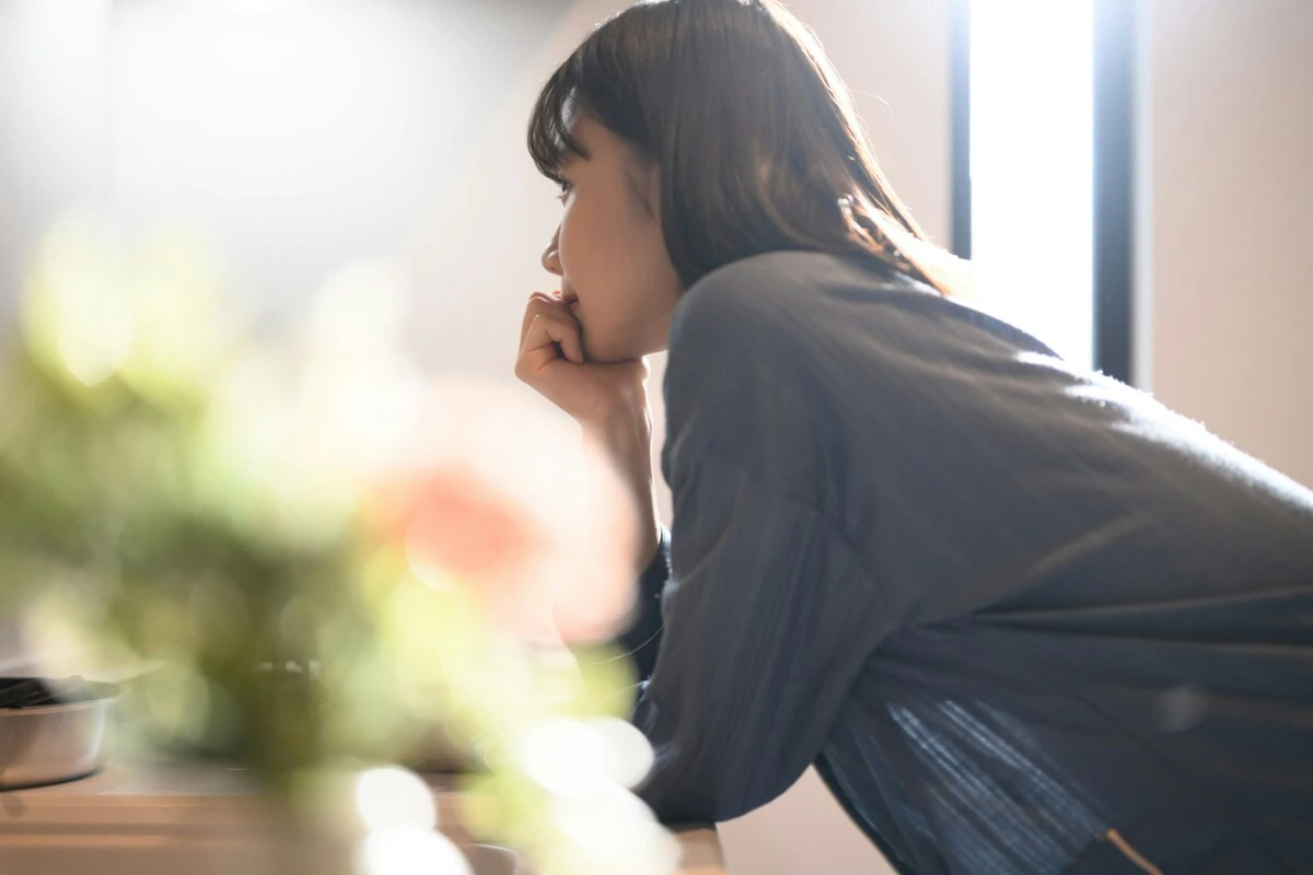 女性　　窓　暗い　家