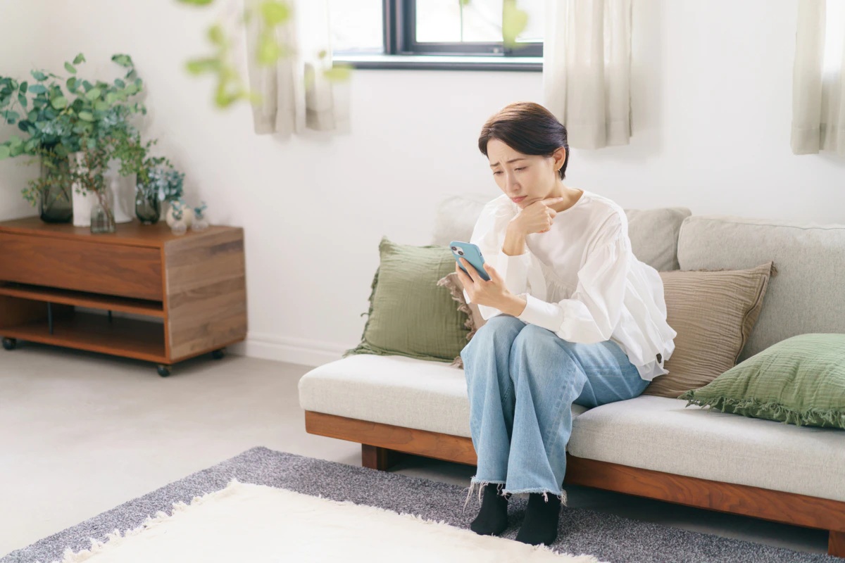 悩む　女性　リビング