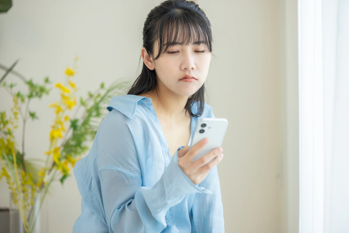 スマホ　女性　イライラ　リビング