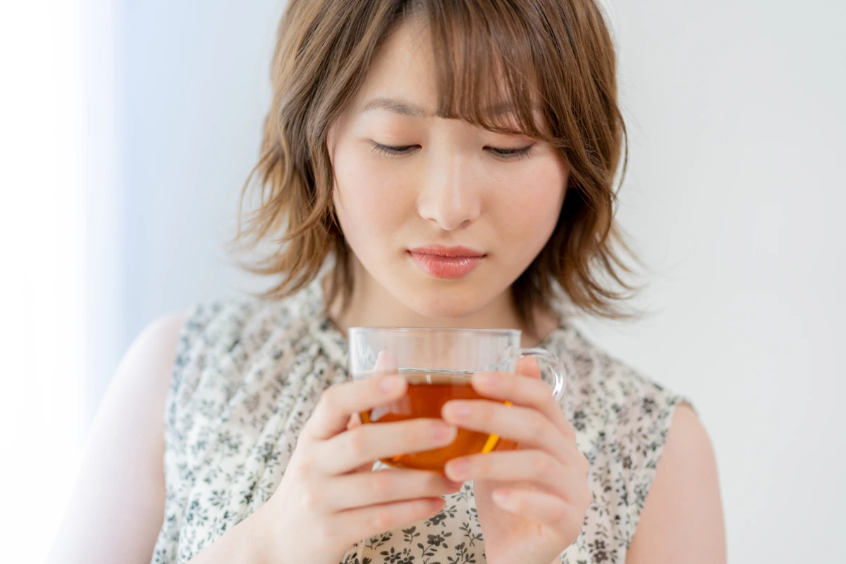 女性　俯く　茶髪　カップ