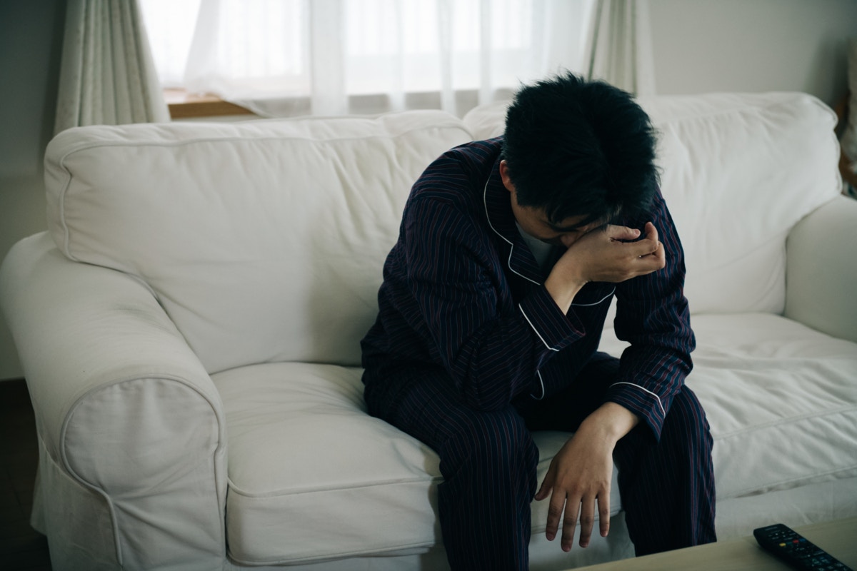 男性　落ち込む　朝　リビング