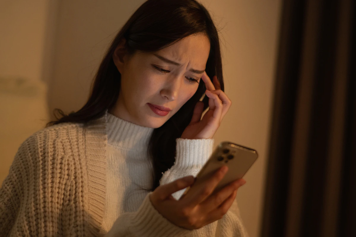 暗い　女性　スマホ　頭痛