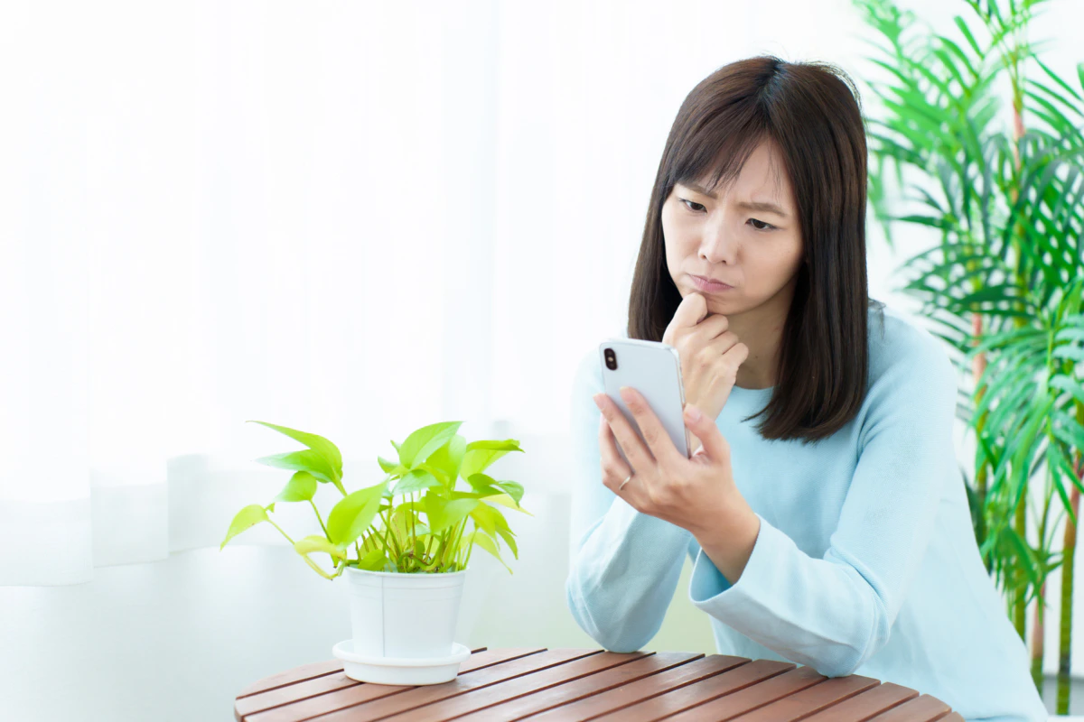 女性　スマホ　困った顔