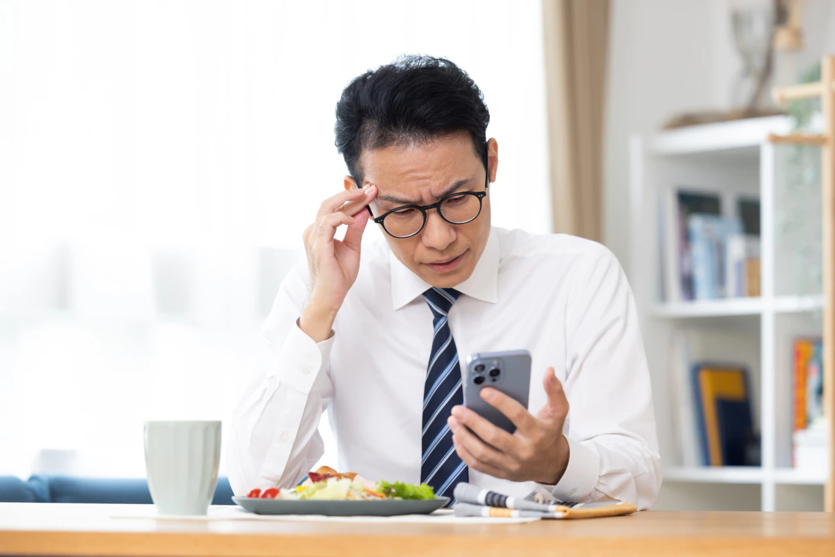 男性　食事　スマホ
