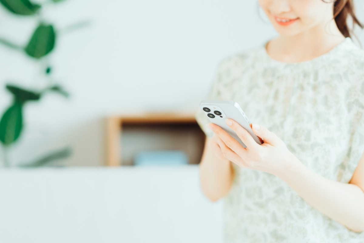 女性　スマホ　手元　家