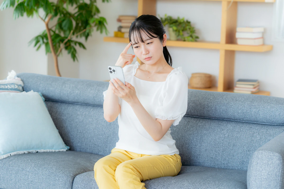 スマホ　女性　リビング　悩む