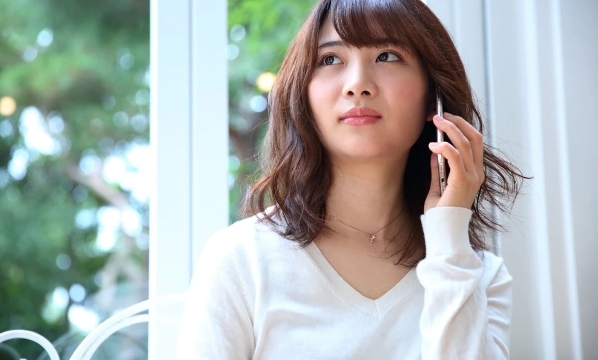 女性　スマホ　カフェ　通話　不安