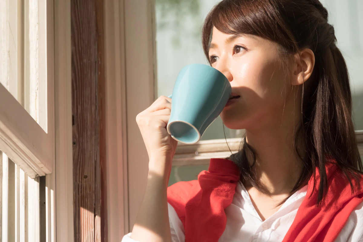 窓　外　見る　女性　夕方　リビング