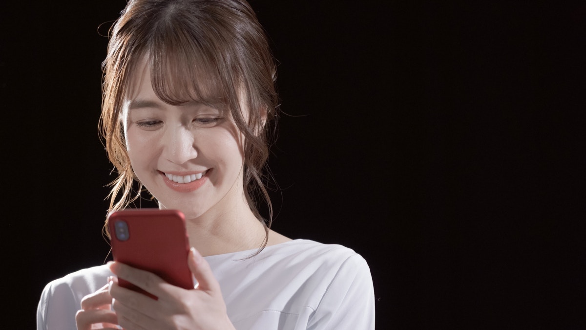 女性　スマホ　笑う　暗闇