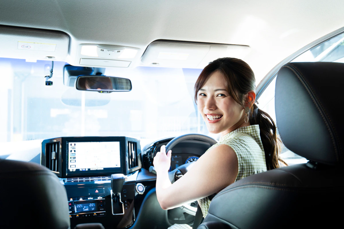 女性　運転　振り返る　笑顔